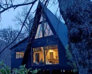 Casa alpina terminada y encendida al atardecer